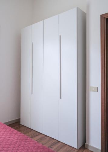 a white wardrobe in a bedroom with a pink rug at Residence Ristorante Il Paradiso in Guardistallo