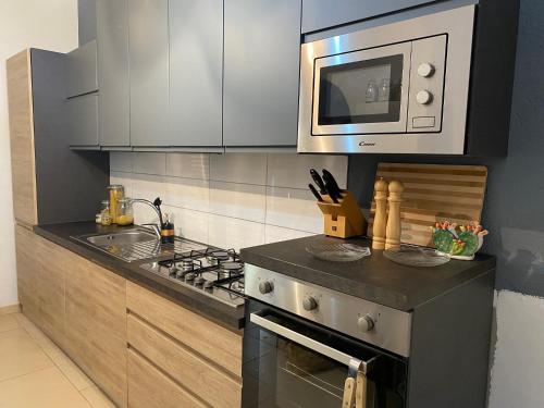 a kitchen with a stove and a microwave at Villa Medusa in Tre Fontane