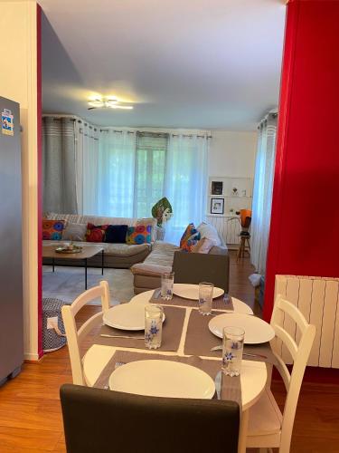 un salon avec une table, des chaises et un canapé dans l'établissement Appartement lumineux 4 personnes, à Enghien-les-Bains
