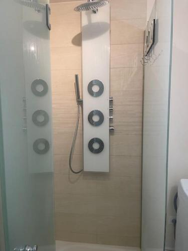 une douche dans une salle de bain avec une porte vitrée dans l'établissement Apparemment front de mer, à Ouistreham