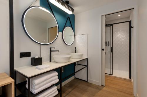 a bathroom with two sinks and a mirror at Aloft Hotel, By Marriott in Dijon