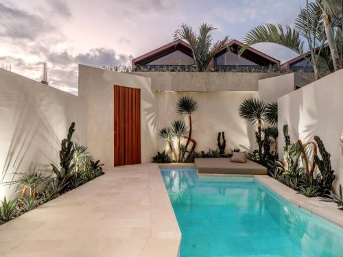 una casa con piscina en un patio en Blacksand Villas Echo Beach Canggu B4, en Canggu