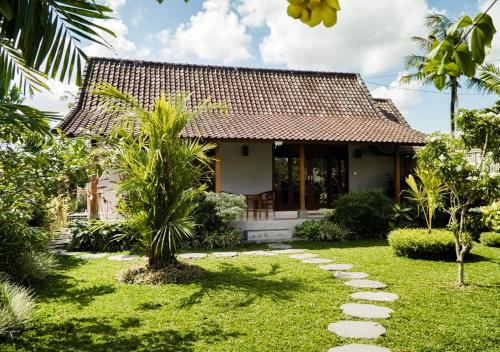 dom z ogrodem przed nim w obiekcie Green Coconut Cottage w mieście Ubud