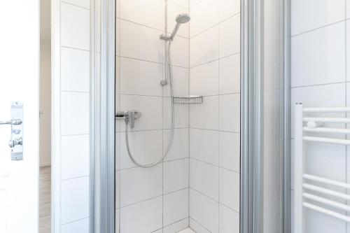 une douche avec pommeau de douche dans une salle de bain dans l'établissement Summer Diek Summerdiek 6, à Sankt Peter-Ording