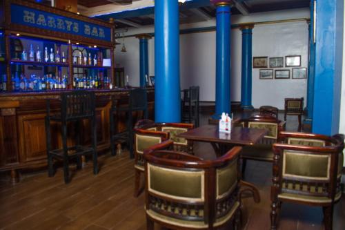 a bar with wooden tables and chairs and blue columns at Cocoa Luxury Resort, Nyali, Mombasa in Mombasa