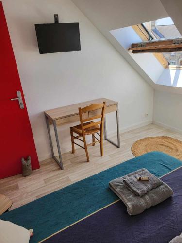 a room with a desk and a chair and a table at Auberge de la vallée de la douve in L'Etang-Bertrand