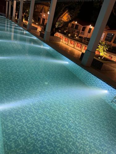 a large swimming pool with lights in a building at SANTINIKETAN RETREAT, Bolpur in Shānti Niketan