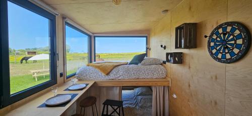 ein Schlafzimmer in einem winzigen Haus mit einem großen Fenster in der Unterkunft Tiny House La Cavalerie, au milieu des chevaux ! in Annouville-Vilmesnil