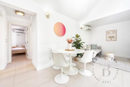 a white dining room with a white table and chairs at Oasis con piscinas y jardines en Maspalomas in Maspalomas