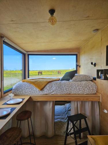 - une chambre dans une petite maison avec une grande fenêtre dans l'établissement Tiny House La Cavalerie, au milieu des chevaux !, à Annouville-Vilmesnil