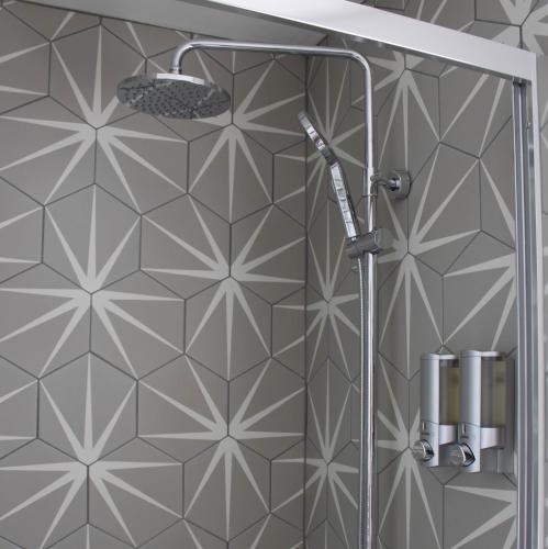a shower in a bathroom with a tile wall at Buttermere Cottage in Banff