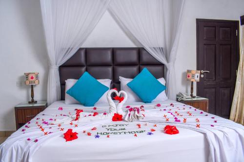 a bedroom with a bed with red flowers on it at Cocoa Luxury Resort, Nyali, Mombasa in Mombasa