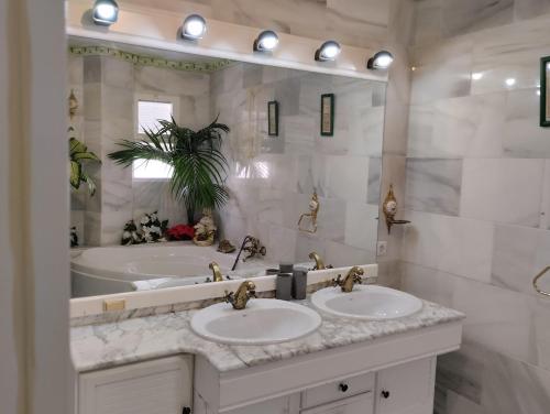 une salle de bain avec deux lavabos et un grand miroir dans l'établissement casa con terraza privada, à Nerja