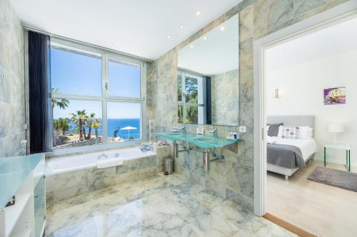 a bathroom with a tub and a sink and a bed at Villa Bay Blue in Llucmajor