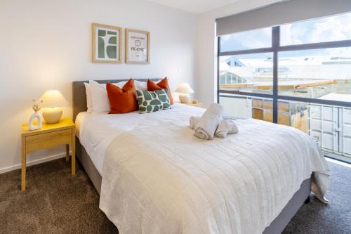 クライストチャーチにある2 Bed, 2 Bath w Sofa Bed - Great Cafes Nearbyのベッドが2つと大きな窓がある寝室