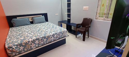 a bedroom with a bed and a desk and a chair at Sathyam Resorts in Dharmapuri