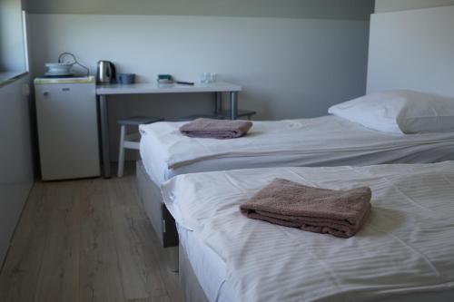 two beds in a room with towels on them at Bon Ton in Szczecin