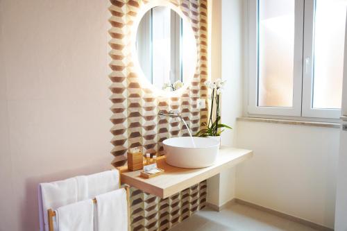 een badkamer met een wastafel en een spiegel bij La chicca in Matera