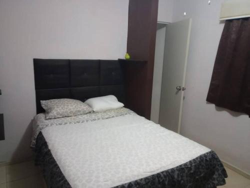 a bed with two pillows on it in a room at Departamento en Fraccionamiento in Oacalco