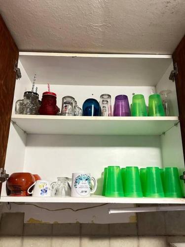 a shelf filled with different colored cups and dishes at Departamento en Fraccionamiento in Oacalco