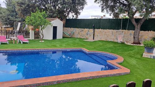 a swimming pool in a yard with green grass at Casa Albarracín in Setenil