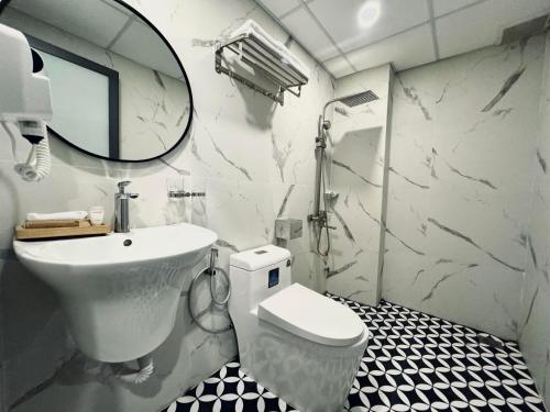 uma casa de banho com um lavatório, um WC e um espelho. em LION 8 Hotel em Can Tho