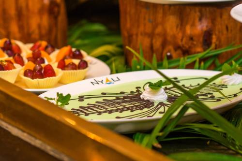 a plate of food with fruit on a table at Cocoa Luxury Resort, Nyali, Mombasa in Mombasa
