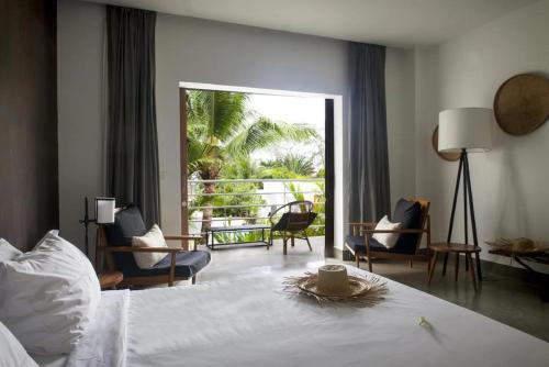 a hotel room with a bed and a balcony at Mittali Beach Hotel in Sihanoukville
