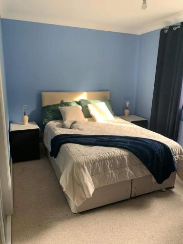 a bedroom with a large bed with blue walls at Trevonnen in Llyswen