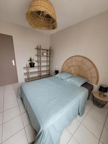 a bedroom with a large bed with a basket on the ceiling at Le Capestang in Canet-en-Roussillon