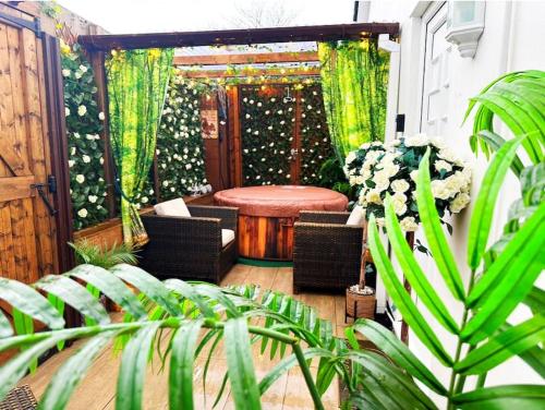 a patio with a table and chairs and plants at Squirrel Hideaway with Hot Tub in Formby, Liverpool in Formby