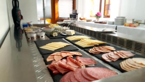 a counter with meats and cheese and other foods at Hotel Schneiderhof in Braunlage
