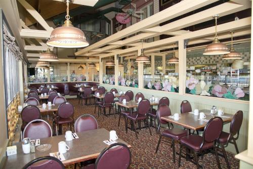 a restaurant with tables and chairs and a bar at Canadas Best Value Inn Whitecourt in Whitecourt