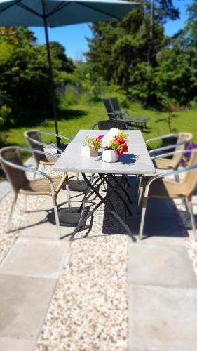 a white table with flowers on it with chairs at Hotel Schneiderhof in Braunlage