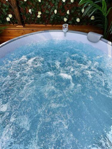 a hot tub filled with blue water in a backyard at Squirrel Hideaway with Hot Tub in Formby, Liverpool in Formby