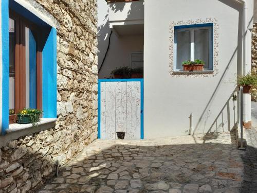 a white building with blue doors and a window at casa vacanze gioema baunei in Baunei