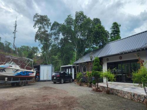 a house with a boat parked next to a garage at Halo Retreat in Hòa Bình