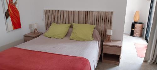 - une chambre avec un lit et 2 oreillers jaunes dans l'établissement Magnifique appartement entre mer et montagne, à Tiuccia