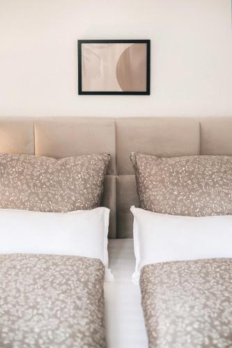 two pillows on a bed with a picture on the wall at Gemütliche Oase in der Altstadt in Löbau