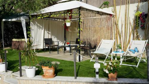 a garden with a tent and chairs and plants at Appartamento vista lago in Sulzano