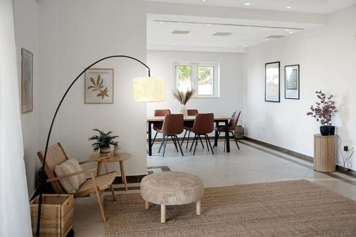 a living room with a table and chairs at Varkiza Seaside and Views Retreat with Jacuzzi in Vari