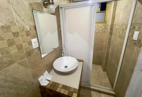 a bathroom with a sink and a shower with a mirror at Hotel Aquario in Mexico City