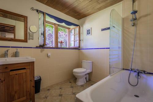 a bathroom with a tub and a toilet and a sink at Domaine du Roucou in Nabirat