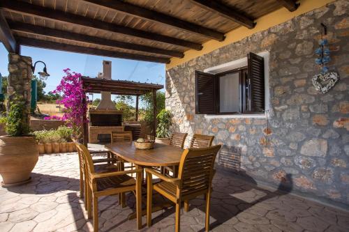 an outdoor patio with a wooden table and chairs at Villa in the Woods in Kolimbia