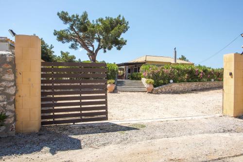 a wooden fence with a house in the background at Villa in the Woods in Kolimbia