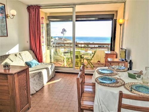 a living room with a table and a view of the ocean at Apartment Les Eaux Vives 1 & 2-5 by Interhome in Saint Pierre La Mer