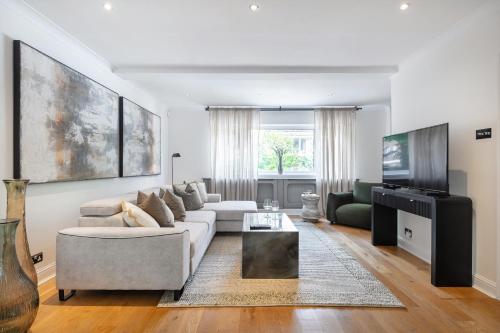 a living room with a couch and a tv at Rare 4beds Townhouse in Kensington with Patio in London