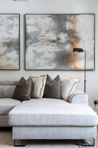 a living room with a couch and two paintings at Rare 4beds Townhouse in Kensington with Patio in London