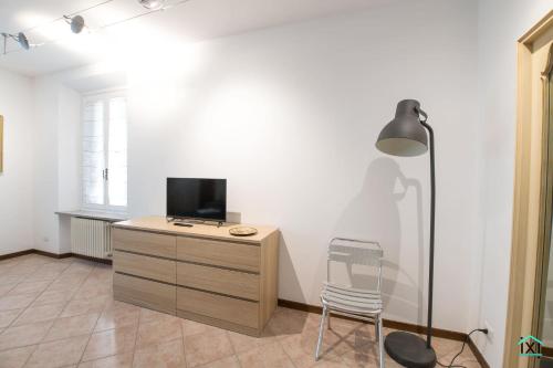 a room with a desk with a tv and a chair at Attico Varese centro - Ixihome in Varese