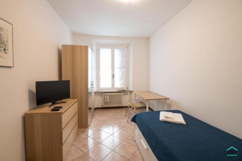 a small bedroom with a bed and a television at Attico Varese centro - Ixihome in Varese